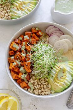 two bowls filled with different types of food and garnished with sprouts