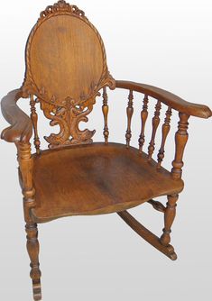 an old wooden rocking chair with carved back and arm rests against a white background,