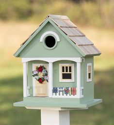 a bird house with flowers and wreaths on it