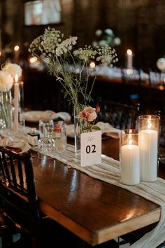 the table is set with candles, flowers and place cards for guests to sit at