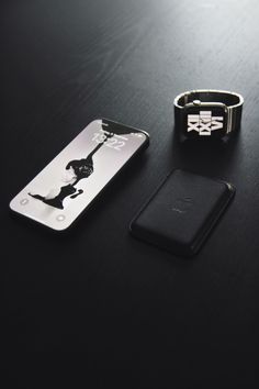 an iphone, watch and wallet sitting on a table