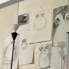 there are drawings on the wall with a lamp