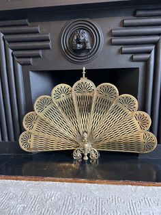 a decorative fan sitting on top of a black table next to a fire place mantle