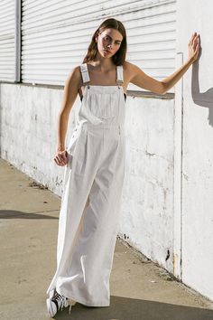 A woven overall featuring adjustable straps, center front pocket, front pleated pant, side and back pockets and wide leg. 100% Cotton