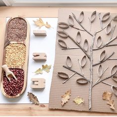 an art project made out of cardboard with leaves, nuts and other things to make it look like a tree