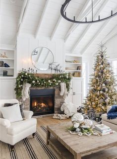 a living room filled with furniture and a christmas tree in front of a fire place