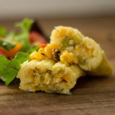 a close up of food on a wooden table with lettuce and carrots