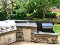 an outdoor kitchen with grill, sink and cabinets