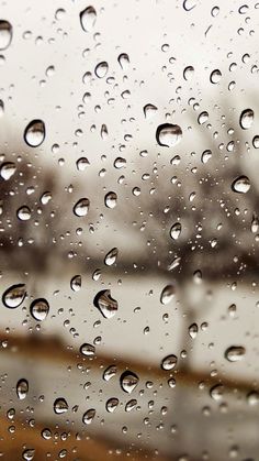 rain drops on a window with buildings in the background