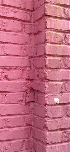 a brick wall painted pink with white paint