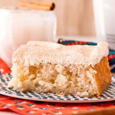 a piece of cake sitting on top of a plate next to a glass of milk