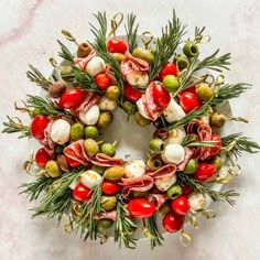 a wreath made out of different types of vegetables and meats on a marble surface