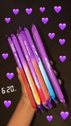 four different colored pens sitting on top of each other in the shape of heart shapes