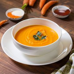 a bowl of carrot soup on a white plate