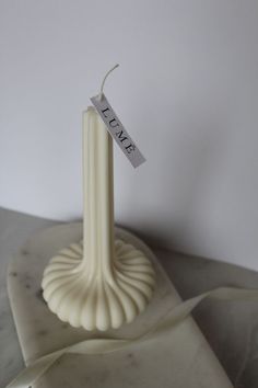 a white candle with a tag that says love on it