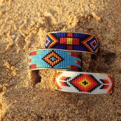 A metallic cuff with a beaded design in brilliant colors calling out a true southwest feel. Band is 2 3/8 inches in diameter, Cuff is approximately 1 inch wide. Loom Designs, Beaded Bangles, Seed Bead Jewelry Patterns, Beaded Hair Clips, Bead Loom Designs, Beaded Bangles Bracelets, Beaded Hair, Beadwork Designs, Land Of Enchantment