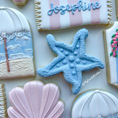 decorated cookies are displayed on a white tablecloth with pink and blue decorations, including seashells