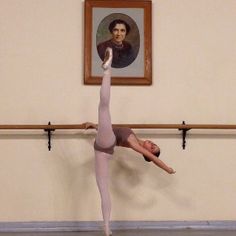 a person doing a handstand in front of a painting