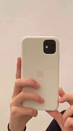 a woman taking a selfie with her iphone in front of her face and holding it up to the camera