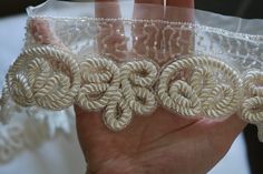 a person holding three pieces of lace in their hand