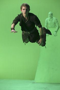 a man is suspended in the air on a green screen