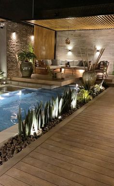 an indoor swimming pool surrounded by plants and lights