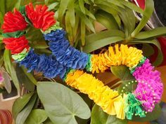 colorful flowers are arranged in the shape of a heart on top of some green leaves