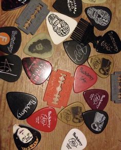 many different guitar picks are arranged on a table