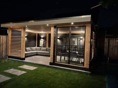 an outdoor living area at night with lights on