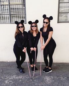 three women in mickey mouse ears and black outfits pose for a photo with their canes