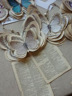 several butterflies are sitting on top of an open book with pages cut out to look like books