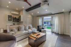 a living room filled with furniture and a ceiling fan