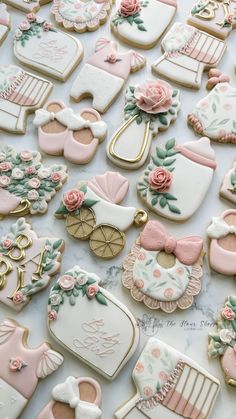 baby shower cookies are arranged on a white tablecloth with pink and gold accents,