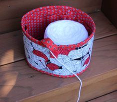 a red and white hat sitting on top of a wooden bench