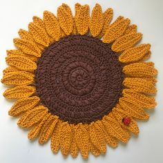 a crocheted sunflower on a white surface