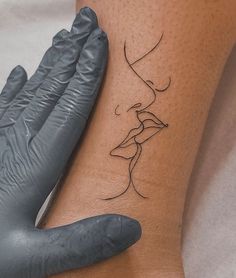 a woman's hand with a tattoo on her left arm next to a glove