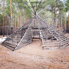 a wooden structure made out of sticks in the woods