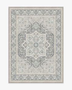 a rug with an ornate design on the front and back side, in grey tones