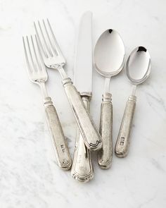 an assortment of silverware on a marble surface