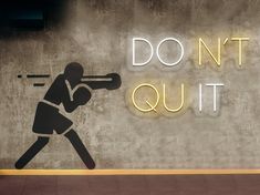 a neon sign that says don't quit out with a baseball player hitting the ball