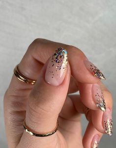 a woman's hand with pink and gold nail polish