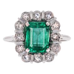 Ring in 18 karat white gold, eagle head hallmark. An elegant vintage ring, its rectangular setting stylizes a flower whose petals are adorned with antique-cut diamonds separated by small white gold bars, and the center is adorned with a degree-cut emerald held in place by 4 claws. The basket is made of gold wire. Weight of the emerald : 2.61 carats approximately. Emerald accompanied by its laboratory certificate. Total weight of the diamonds : 0.30 carat approximately. Height : 15.3 mm approximately, width : 13.5 mm approximately, thickness : 8.3 mm approximately, width of the ring at the base : 1 mm approximately. Total weight of the jewel : 4,3 g approximately. US Size : 7,5 ; Free resize, please contact us. Antique jewelry - French work of the 1970s. Our opinion : Antique daisy rings ma Formal Rectangular Emerald Ring With Center Stone, Classic Rectangular White Gold Emerald Ring, Classic White Gold Rectangular Emerald Ring, Classic Rectangular Emerald Ring In White Gold, Vintage White Gold Emerald Jewelry, Rectangular Platinum Ring For Formal Occasions, Rectangular Platinum Ring With Center Stone, Platinum Rectangular Ring With Center Stone, Vintage Platinum Ring With Gemstone