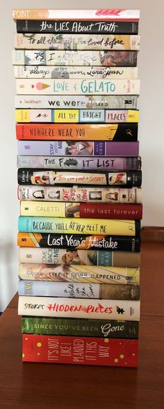 a stack of books sitting on top of a wooden table