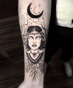 a woman's leg with a tattoo on it and the moon above her head