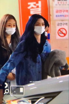 two women wearing face masks at an airport