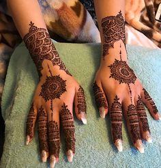 two hands with henna tattoos on them