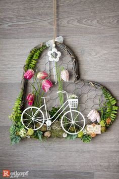 a heart shaped hanging decoration with flowers and a bicycle