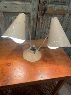 two lamps sitting on top of a wooden table