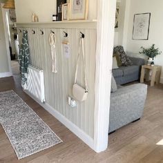 a living room filled with furniture and hanging items on the wall next to a couch