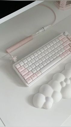 a computer keyboard and mouse sitting on a white desk with cloud shaped plugged in